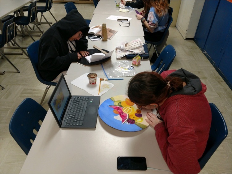 students painting cardboard clocks